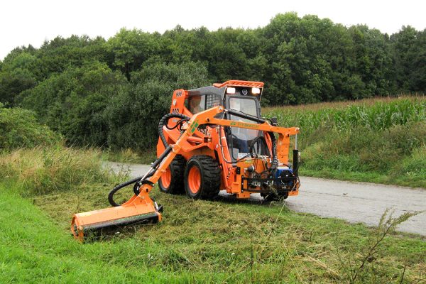 Compact brush cutter arm for wheel loaders and backhoe loaders